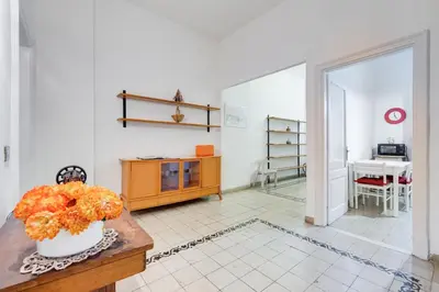 a living room with a table with a vase of flowers at Appartamento con 3 camere da letto e 2 bagni vicino al Vaticano in Rome