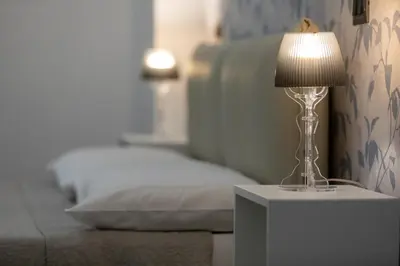 a lamp sitting on a table next to a bed at Comfy Vatican Suite in Rome