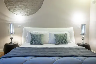 a bedroom with a large bed with two lamps at Cardilli Luxury Rooms in Rome