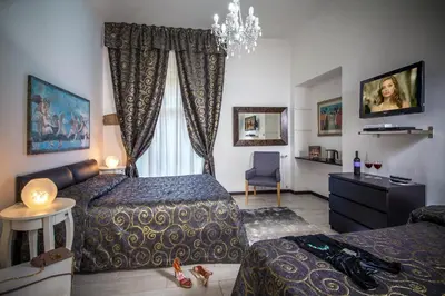 a hotel room with two beds and a chandelier at Roma Central Guest House in Rome