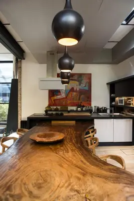 a large wooden table in a kitchen with aendant light at Loft Spazio Panieri Unique place in Trastevere in Rome