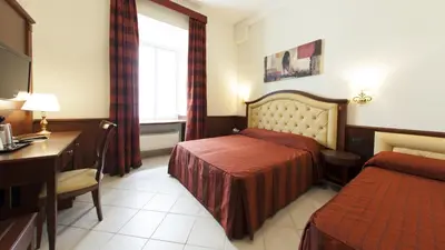 a hotel room with a bed and a desk at Domus Augusta in Rome