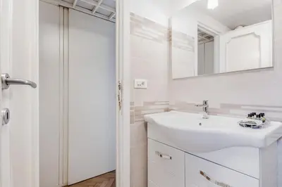 a white bathroom with a sink and a mirror at Giulia's holidays in Rome