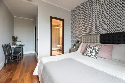 a bedroom with a large white bed and a desk at Suite 36 in Rome