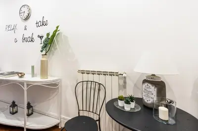 a table with a lamp and a chair in a room at Suite 36 in Rome