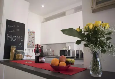 a kitchen counter with a bowl of fruit and a vase of flowers at Suite GG in Vatican in Rome