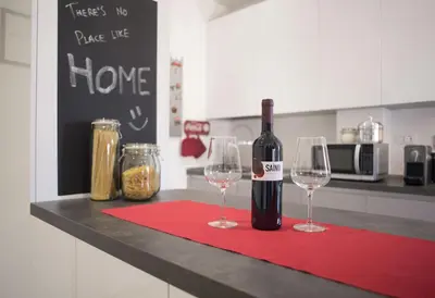 a bottle of wine sitting on a counter with two wine glasses at Suite GG in Vatican in Rome
