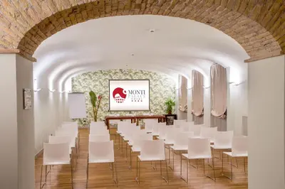 a room with white chairs and a painting on the wall at Monti Palace Hotel in Rome