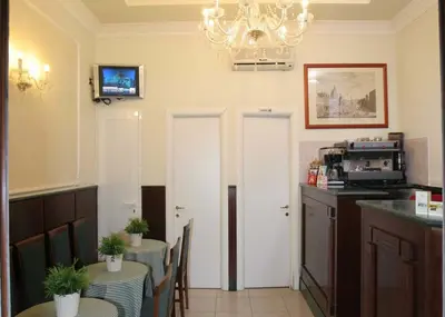 a dining room with two tables and a chandelier at Hotel Chicago in Rome