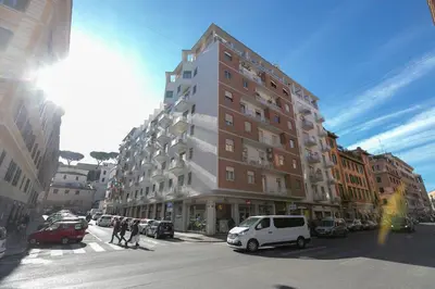 a tall building on a busy city street with cars at All'Ombra dei Musei Vaticani in Rome