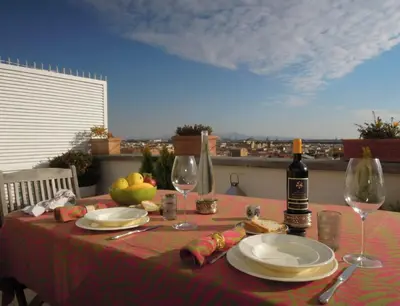 a table with a bottle of wine and two glasses at Penthouseinrome in Rome