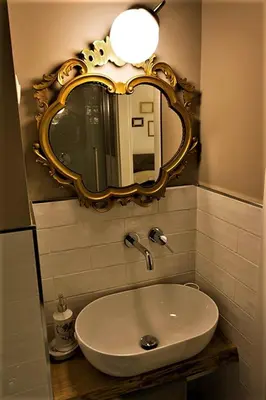 a bathroom with a sink and a mirror on the wall at St. Peter's Luxury Rooms in Rome