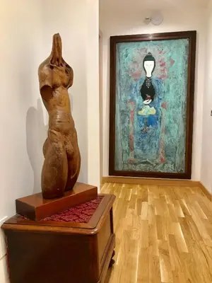 a statue sitting on a chest in front of a painting at Biancalunagiulia in Rome