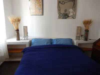 a bedroom with a blue bed and two vases at Porto Fluviale House in Rome