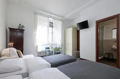 a hotel room with two beds and a bathroom at Maison Colosseo (Via dei Querceti 24) in Rome