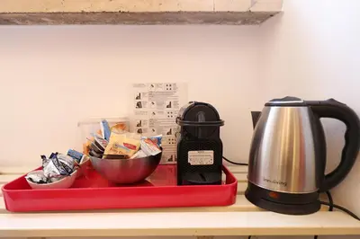 a red tray with a coffee maker and a tea kettle at Maison Colosseo (Via dei Querceti 24) in Rome