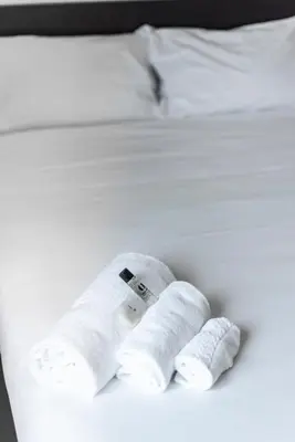 a white bed with two rolled up towels on it at St. Paul Palace Relais in Rome