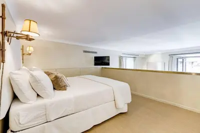 a bedroom with a white bed with pillows on it at Luxurious loft facing the Pantheon in Rome