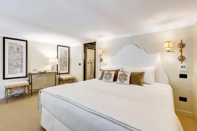 a bedroom with a large white bed and a desk at Luxurious loft facing the Pantheon in Rome