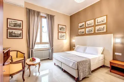 a bedroom with a bed and a desk and a window at La Residenza Suites in Rome