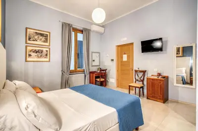 a hotel room with a bed and a television at La Residenza Suites in Rome