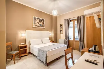 a hotel room with a bed and a desk at La Residenza Suites in Rome