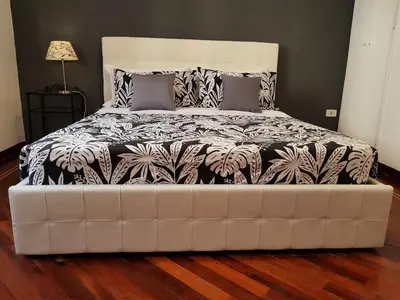 a bed with a black and white comforter in a room at Myomax Guesthouse Hospety Group in Rome