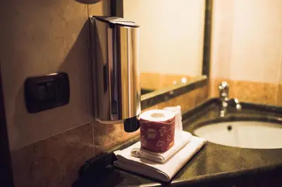 a bathroom with a toilet paper dispenser and a sink at Hotel Robinson in Rome