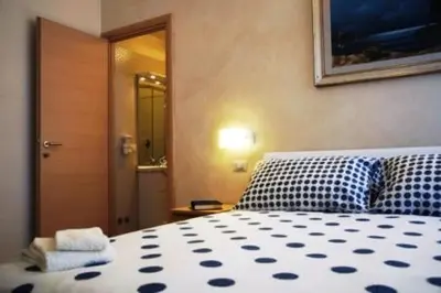 a bedroom with a bed with blue and white sheets at Bed & Breakfast Agli Horti Sallustiani in Rome