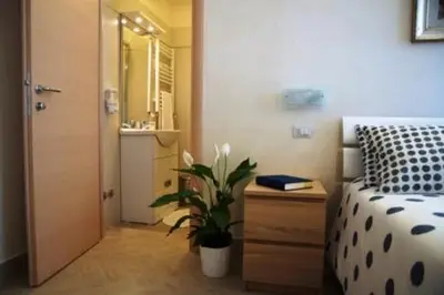a bedroom with a bed and a bathroom with a plant at Bed & Breakfast Agli Horti Sallustiani in Rome