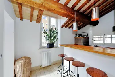 a kitchen with wooden ceilings and stools in a room at Pantheon Stylish Attic in Rome