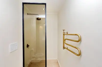 a bathroom with a shower with a gold handle at Pantheon Stylish Attic in Rome