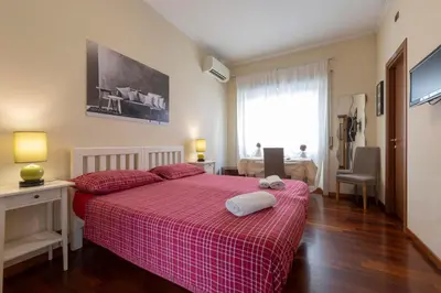 a bedroom with a red bed with two towels on it at AnnoDomini in Rome