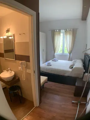 a bedroom with a bed and a sink and a mirror at Vatican Garden House in Rome