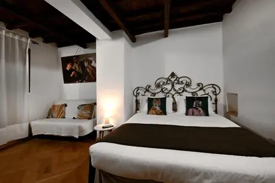 a bedroom with a large bed and a chair at Vicolo 22 - Residenze Romanae in Rome