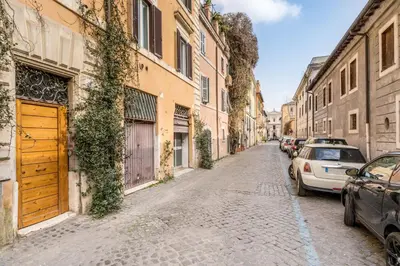a cobblestone street with parked cars and buildings at Trastevere Stylish in Rome