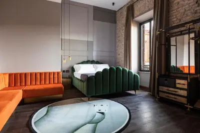 a bedroom with a bed and a couch and a table at Chapter Roma in Rome