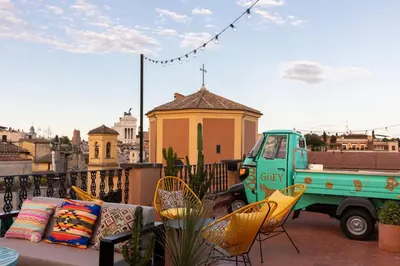 a green truck parked on a balcony with chairs at Chapter Roma in Rome