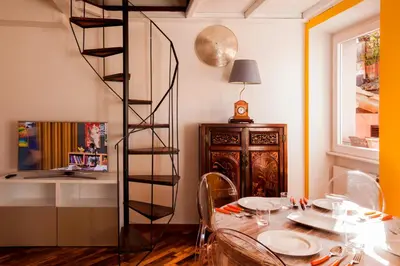 a dining room with a table and a spiral staircase at Home D'elite Navona in Rome