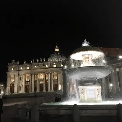 a fountain in front of a large building at night at Vatican Central Suites in Rome