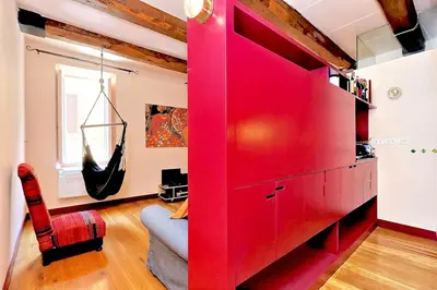a red cabinet in a living room with a couch at delCINQUE 26 - Loft in Trastevere in Rome