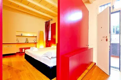 a room with a bed and a red wall at delCINQUE 26 - Loft in Trastevere in Rome