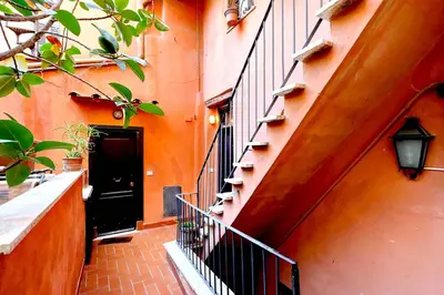 an orange building with a staircase and a black door at delCINQUE 26 - Loft in Trastevere in Rome