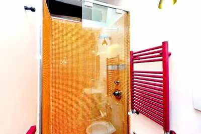 a bathroom with a shower with a glass door at delCINQUE 26 - Loft in Trastevere in Rome
