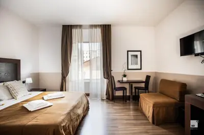 a hotel room with a bed and a chair and a table at Hotel Boutique Nazionale in Rome
