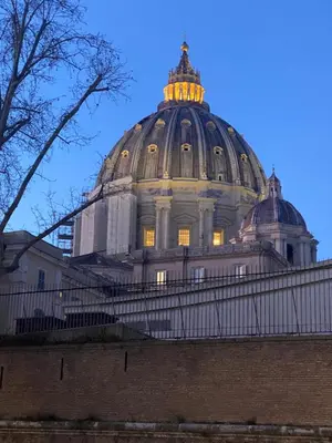 a dome of a building with yellow lights on it at Vatican Garden in Rome