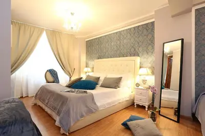 a bedroom with a large bed and a mirror at Liberty Vatican Suites - Liberty Collection in Rome