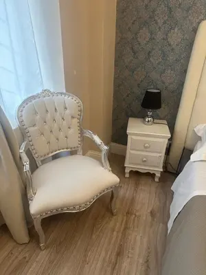 a bedroom with a chair and a bed and a nightstand at Liberty Vatican Suites - Liberty Collection in Rome