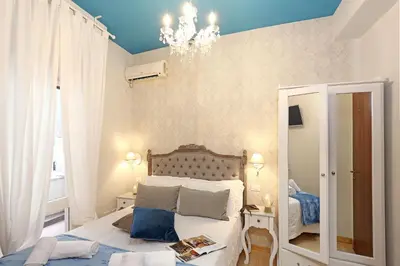 a bedroom with a bed with a mirror and a chandelier at Liberty Vatican Suites - Liberty Collection in Rome