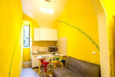 a yellow kitchen with a couch and a table at Rome Best Rent in Rome